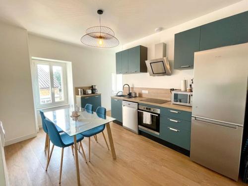 a kitchen with a table and chairs and a refrigerator at Appartement centre-bourg de Bessines in Bessines-sur-Gartempe