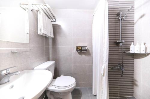 a bathroom with a toilet and a sink and a shower at Hotel Rest Seogwipo in Seogwipo