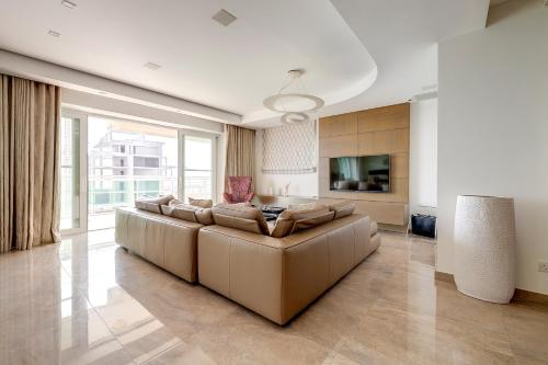 a large living room with a couch and a television at Seafront Apartment Sliema in Sliema