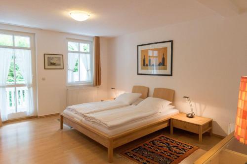 a bedroom with a bed in a room with windows at Villa Eden Binz Typ 4 / Apartment 19 in Binz