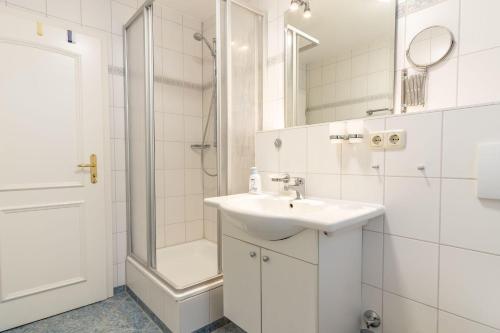 a white bathroom with a sink and a shower at Villa Eden Binz Typ 4 / Apartment 19 in Binz