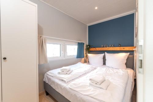een slaapkamer met een bed met witte handdoeken bij Hafenresort Karnin _ Hausboot Pit in Karnin