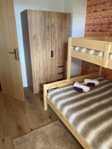 sypialnia z drewnianym łóżkiem piętrowym i ceglaną ścianą w obiekcie Bokun Dunava w mieście Erdut