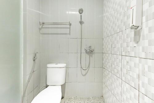 y baño blanco con ducha y aseo. en RedDoorz near Pasar Tarapung Siring Banjarmasin en Banjarmasin