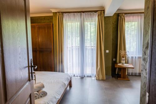 a bedroom with a bed and large windows at Guest House Valevtsi in Valevtsi