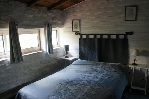 une chambre avec un lit et deux fenêtres dans l'établissement Mas des Collines Gîte de charme avec Piscine, à Châteauneuf-de-Bordette