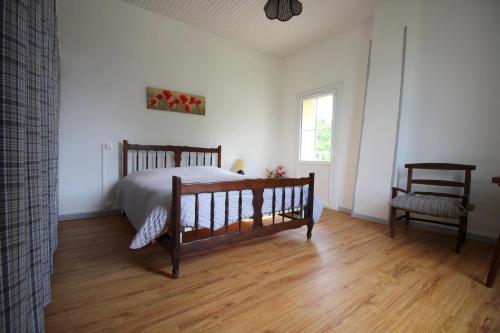 a bedroom with a bed and a chair and a window at Au bon vivre in Saint-Orens-Pouy-Petit