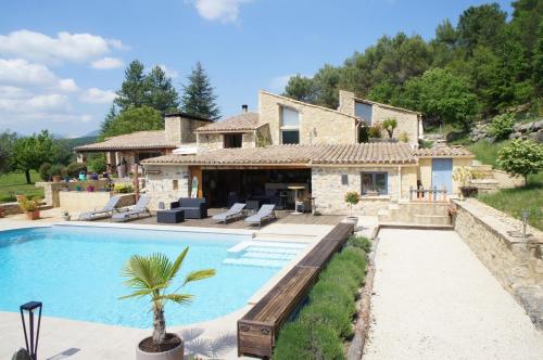 une villa avec piscine devant une maison dans l'établissement Mas des Collines Gîte de charme avec Piscine, à Châteauneuf-de-Bordette