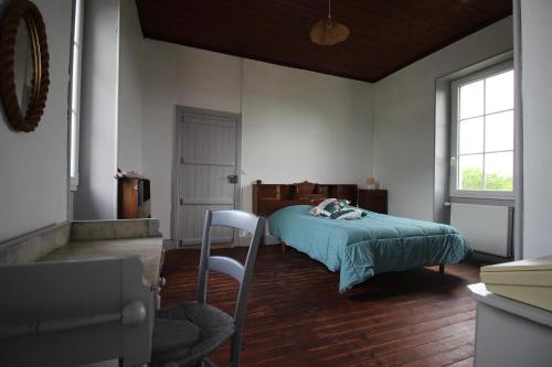 1 dormitorio con 1 cama y 1 silla en Au bon vivre, en Saint-Orens-Pouy-Petit