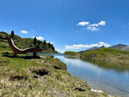 a bench sitting on the side of a body of water at Obertauern Fewo Alps -Top 11 by Kamper in Obertauern