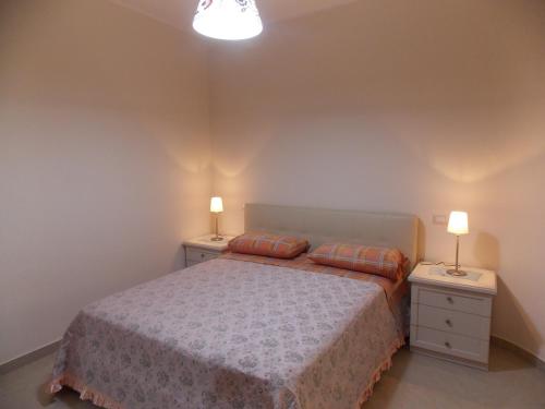 サンタ・テレーザ・ディ・リーヴァにあるB&B Mariafrancescaのベッドルーム1室(ベッド1台、ナイトスタンド2台、ランプ2つ付)