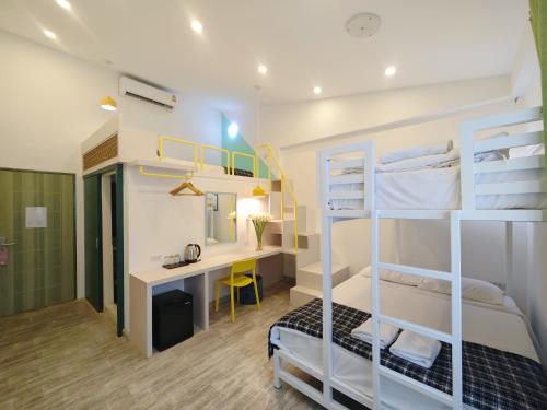 a bedroom with a desk and bunk beds at Ostay Asoke Bangkok in Makkasan
