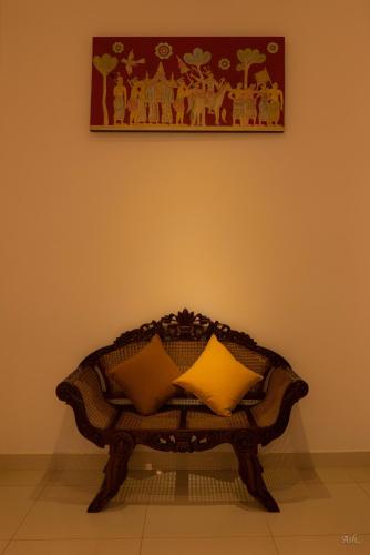 a bench with two pillows on it in a room at Amandara Hills Kandy in Kandy