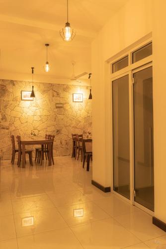 a dining room with a table and a stone wall at Amandara Hills Kandy in Kandy