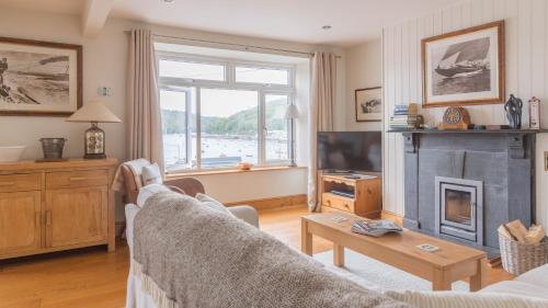 a living room with a couch and a fireplace at Castle House - Polruan in Polruan