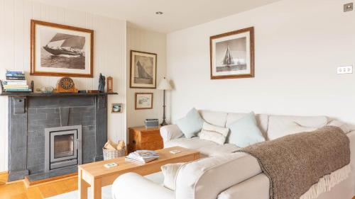 a living room with a white couch and a fireplace at Castle House - Polruan in Polruan