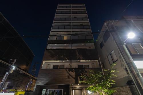 a tall building in a city at night at H2H Dotonbori in Osaka