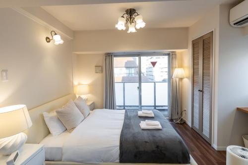 a bedroom with a large bed and a large window at H2H Dotonbori in Osaka