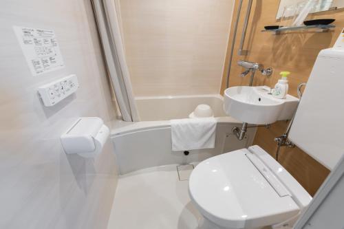 a white bathroom with a toilet and a sink at H2H Dotonbori in Osaka