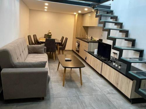 uma sala de estar com um sofá e uma escada em KHAN Apartments LJUBLJANA em Liubliana