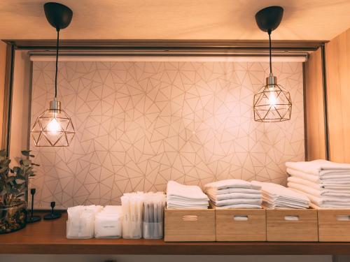大阪市にあるR Hotel-The Atelier Shinsaibashi Eastの白いタオルと照明付きのカウンターが備わるお部屋