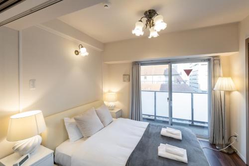 a bedroom with a large bed and a large window at H2H Dotonbori in Osaka
