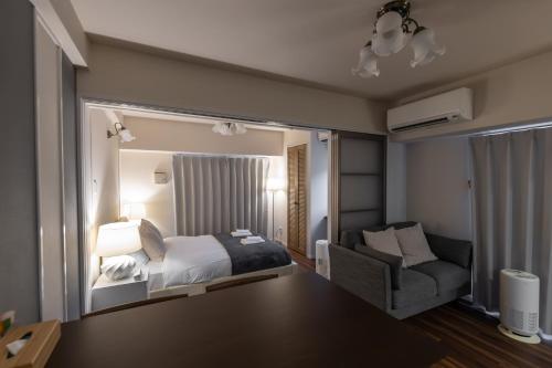 a bedroom with a bed and a chair in a room at H2H Dotonbori in Osaka