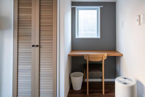 a small room with a table and a window at H2H Dotonbori in Osaka