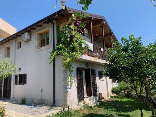 an old house with a balcony and trees at Accommodation "MONTELAGO"- Virpazar,Skadar Lake in Virpazar