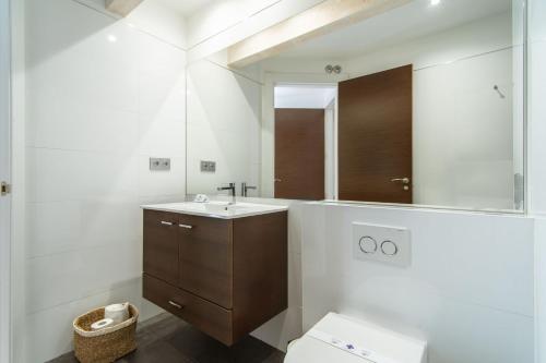 a bathroom with a sink and a mirror and a toilet at Calixto Fernández de la Torre 2 in Valladolid