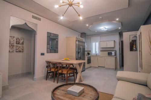 a living room with a table and a kitchen at Apartamentos Turísticos La Baílla in Rota
