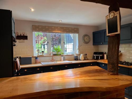 a kitchen with blue cabinets and a wooden counter top at New Forest Spacious Family House in New Milton