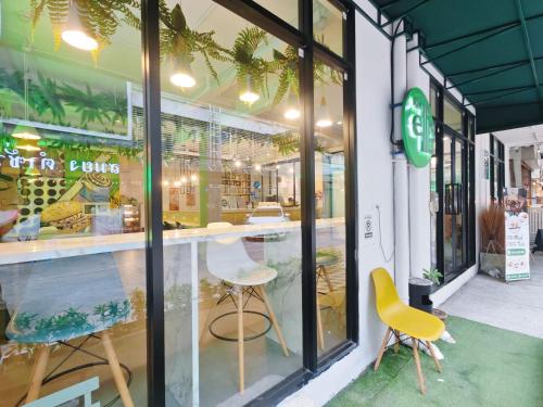 a store with two chairs in front of a window at Ostay Asoke Bangkok in Makkasan
