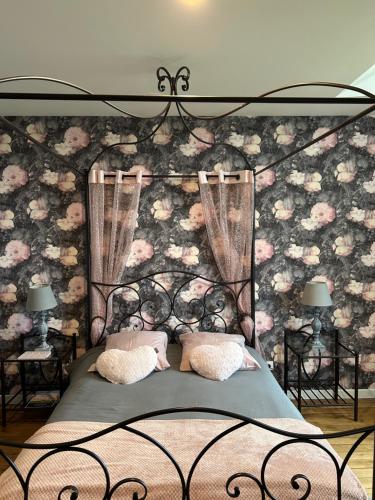 um quarto com uma cama com uma parede floral em Château de la Bouchatte chambre les Roses em Chazemais