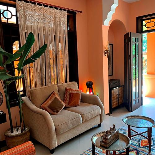 a living room with a couch and a table at The Mansion Hoi An by Minova in Hoi An