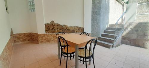 a table and chairs in a room with a staircase at Bilocale Gemma in Arbus