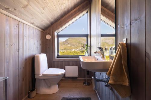 a bathroom with a toilet and a sink and a window at The Magic View of Lofoten - Nature & Sea in Sørvågen