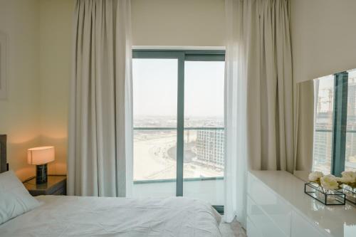 una camera da letto con un letto e una grande finestra di Bright Apartment With Panoramic CityScape Views a Dubai