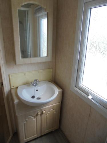 a bathroom with a sink and a mirror and a window at Waterside: Waterside Salisbury:- 6 Berth Large Wrap Around Veranda in Ingoldmells