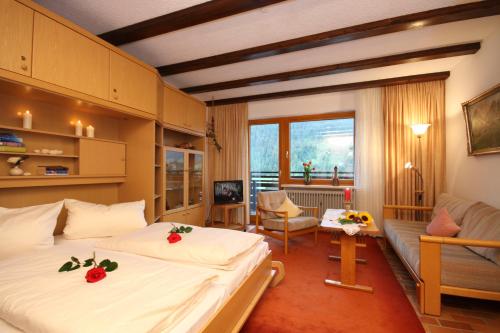 ヒルシュエックにあるSporthotel Walliserのベッド2台とソファが備わるホテルルームです。