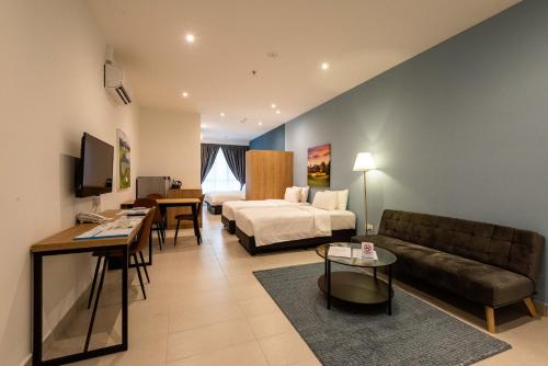 a hotel room with a bed and a couch at The Signature Serviced Suites Puchong in Puchong