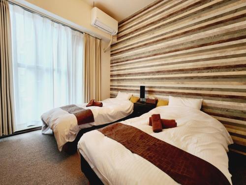金澤的住宿－ダイアナ，酒店客房设有两张床和窗户。