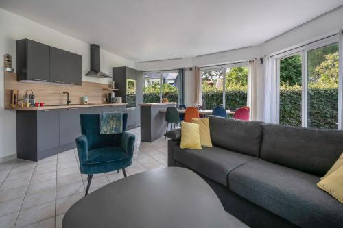 un salon avec un canapé et une cuisine dans l'établissement Appartement cosy et moderne à la Baule-Escoublac, à La Baule