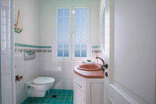 a white bathroom with a toilet and a sink at Boutique Villa Andronice in Tsoukaladhes