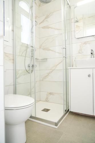 a bathroom with a shower and a toilet and a sink at Meneou Houses by the Sea in Larnaka