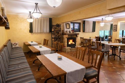 un restaurant avec des tables et des chaises et une cheminée dans l'établissement Guest House Valevtsi, à Valevtsi