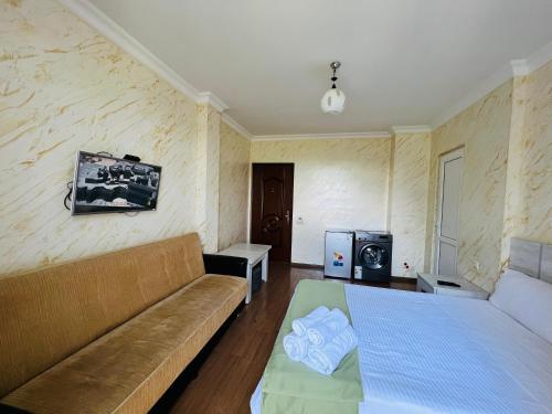 a living room with a couch and a tv at Apartments NITA in Batumi