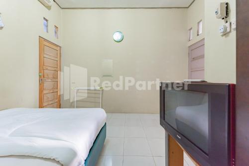 Ένα ή περισσότερα κρεβάτια σε δωμάτιο στο Ana Guest House Syariah Mitra RedDoorz