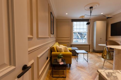 a living room with a yellow chair and a couch at Boutique Apartment in Camden road in London