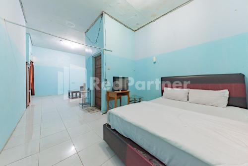 ein Schlafzimmer mit einem großen Bett in einem Zimmer in der Unterkunft Ana Guest House Syariah Mitra RedDoorz in Banjarbaru